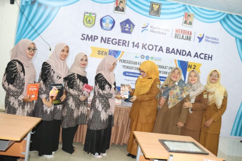 Penyerahan buku dari dosen Prodi Pendidikan Bahasa Inggris USM Kepada Guru SMP Negeri 14 Kota Banda Aceh 