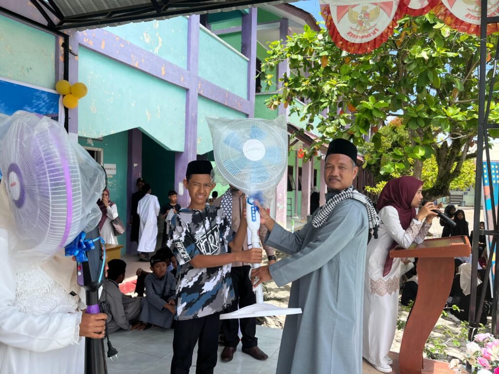 Kepala Sekolah SMPN 1 Seunagan Nagan Raya Misnan. S.Pd.MM Menyerahkan Hadiah Lomba Pawai Takhruf Menyambut Bulan Suci Ramadhan.