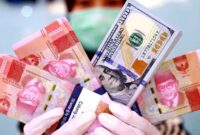 Rupiah Ditutup Menguat.  Karyawan memperlihatkan uang dolar AS diantara uang rupiah di sebuah bank di Jakarta, belum lama ini. Setelah sempat di zona merah, rupiah di pasar spot ditutup menguat ke level Rp14.710 per dolar AS. BeritaSatu Photo/Mohammad Defrizal