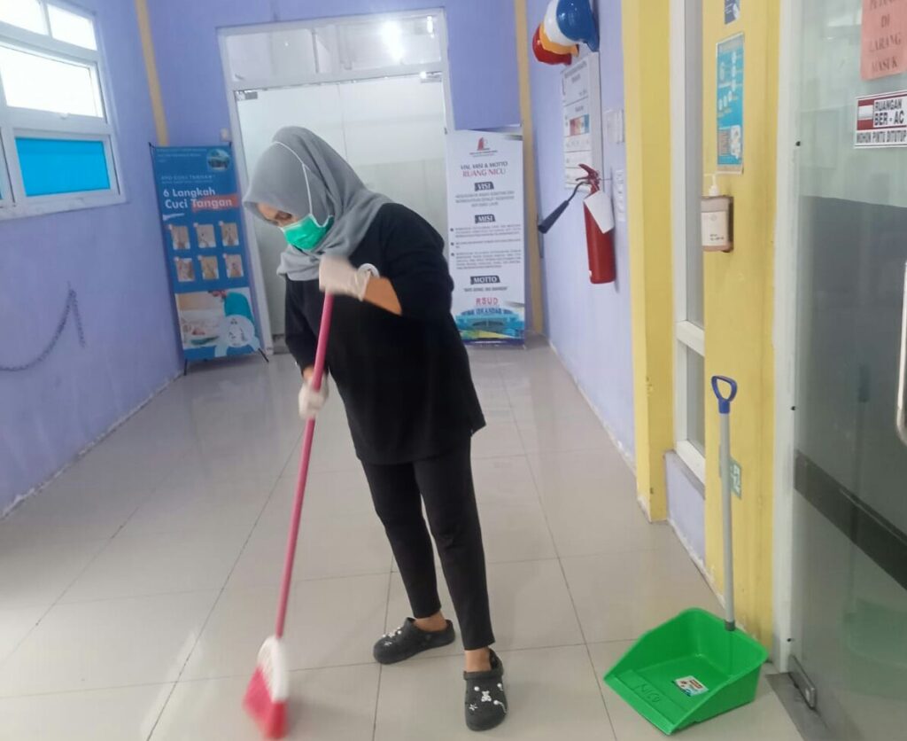 Karyawan Cleaning Service Membersihkan Lantai Ruangan